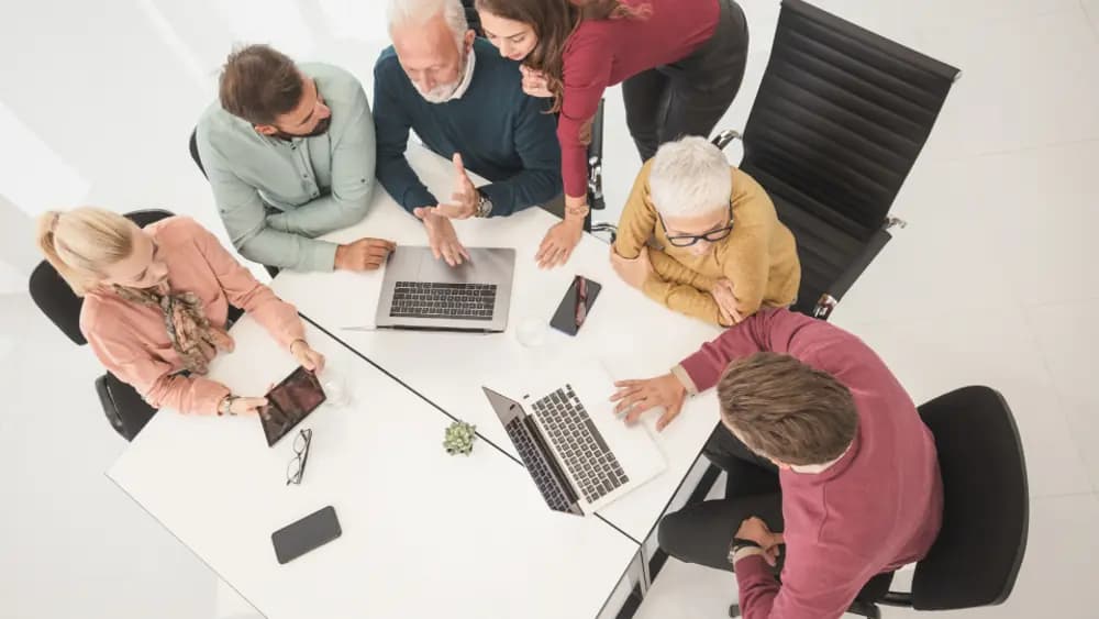 Colleagues in conversation across an office desk