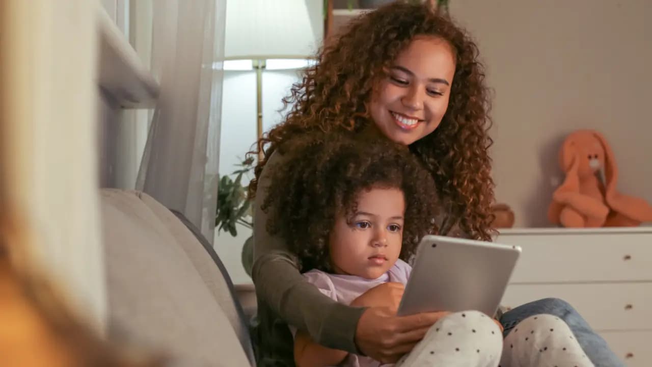 A parent reading something on their phone at home