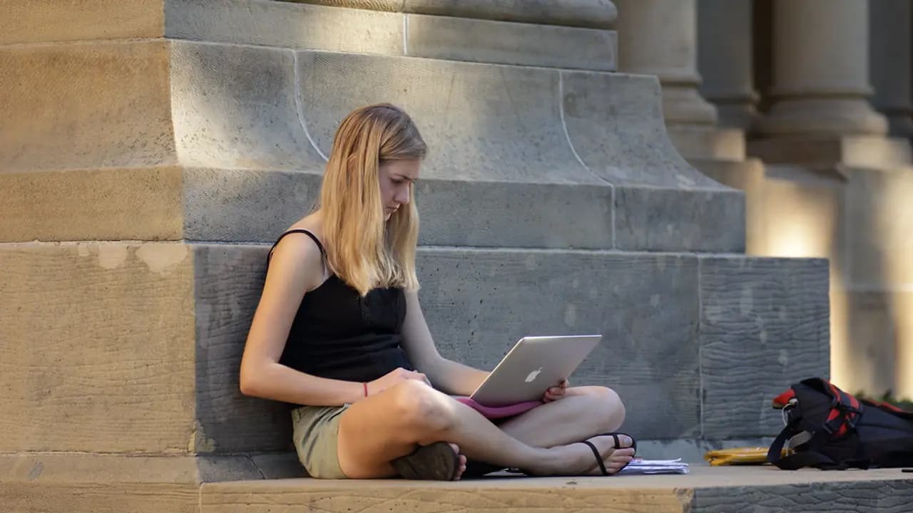 A student working through notes with a laptop open