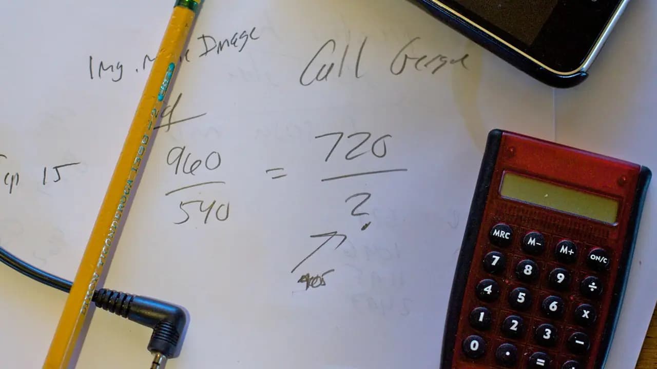 Marks worked out on a whiteboard beside a calculator