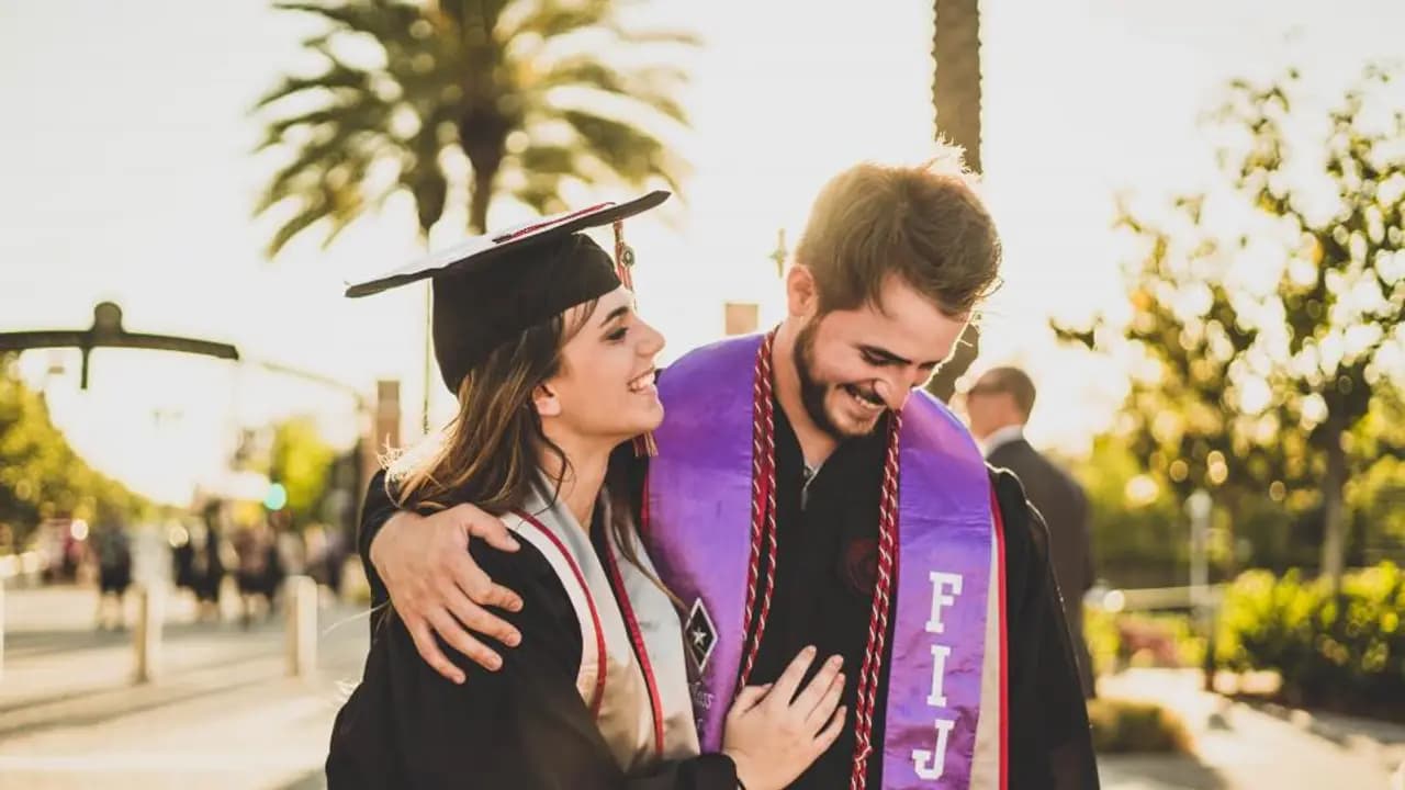 A graduate in cap and gown outside on the day