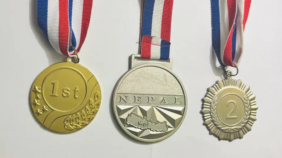 Three medals on striped ribbons — a gold first place, a silver and a bronze