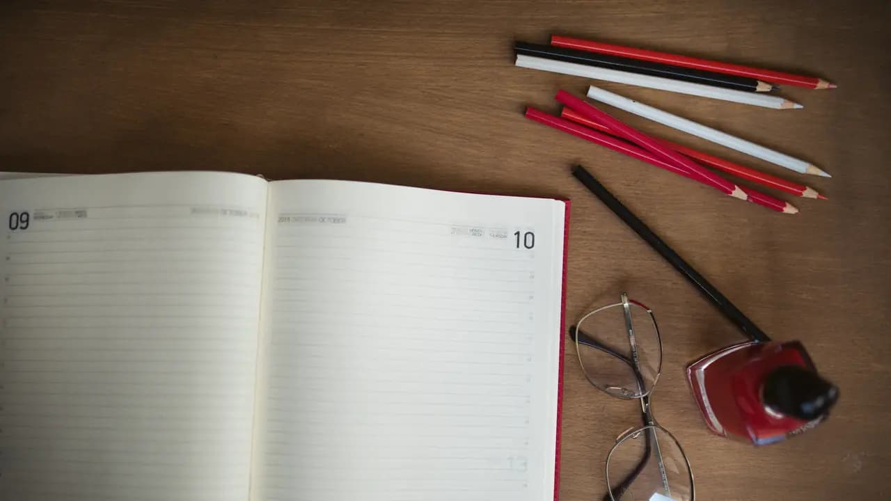 An open planner notebook with pencils laid beside it
