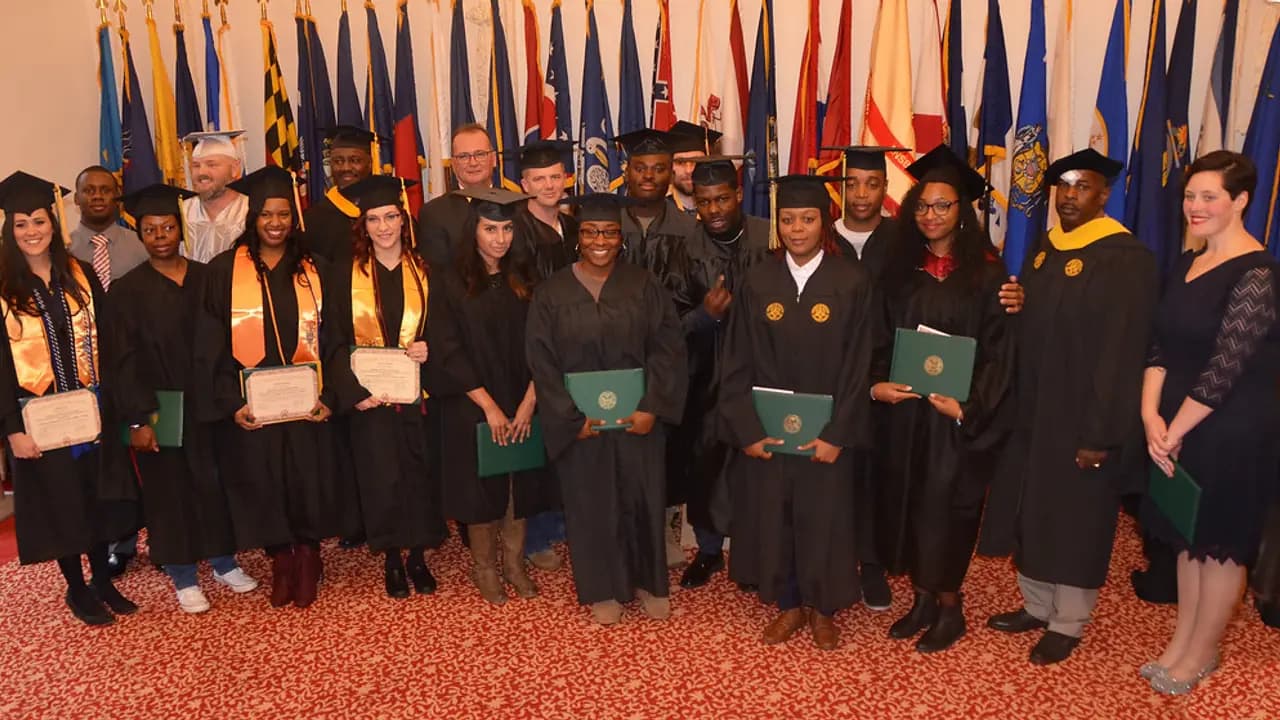 Graduating pupils in gowns holding their certificates